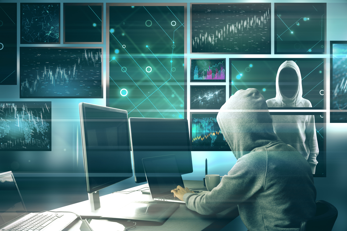 Hooded figure at a desk monitoring multiple data screens, showing how shadow AI increases generative AI security risks